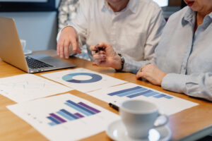 Two professionals reviewing analytics charts and graphs during a strategy meeting, representing how many downloads is good for a podcast