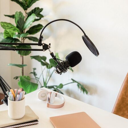 desk with podcast mic and notebooks