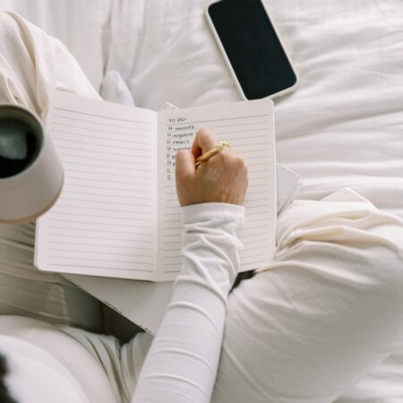 business owner working on podcast workflow organization on notebook
