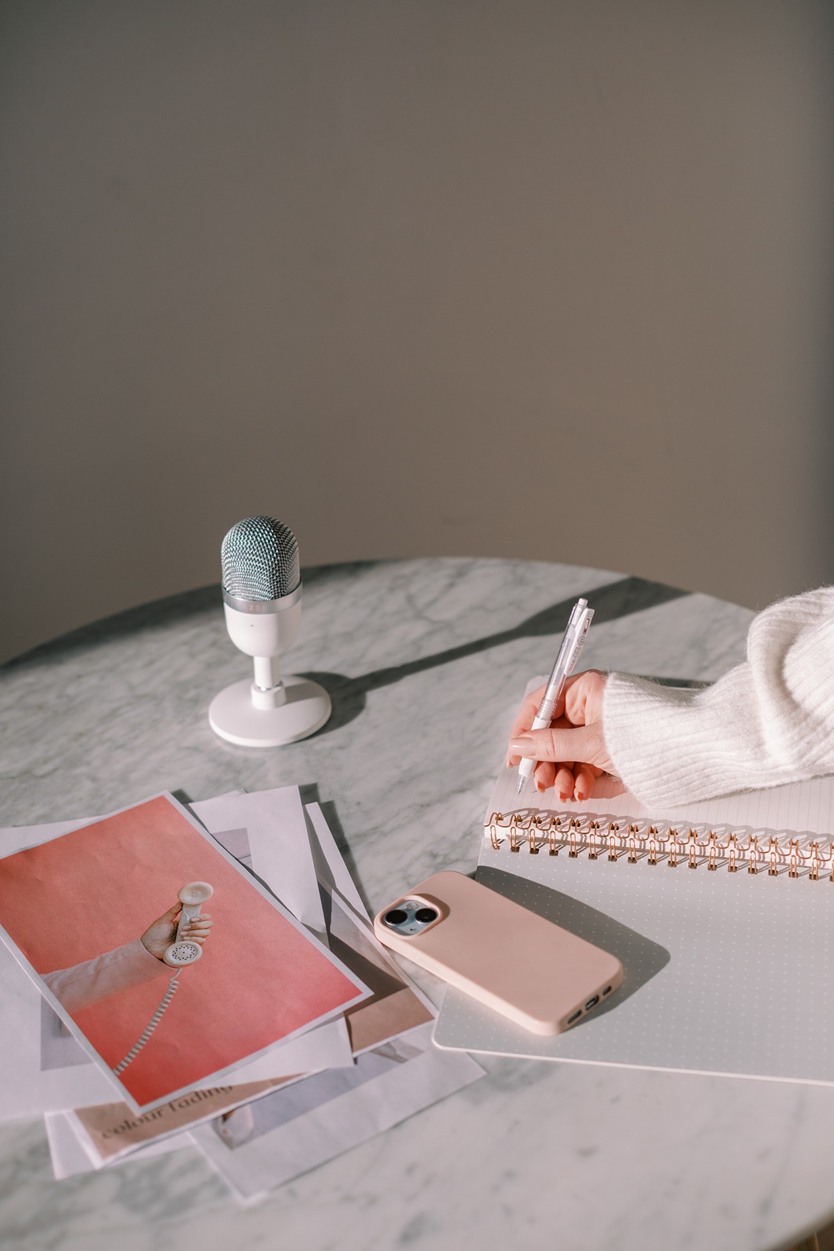 business owner writing in notebook while listening to a podcast