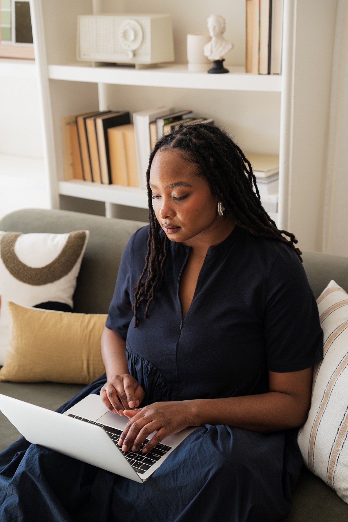 using-ai-for-show-notes woman typing on computer wearing a blue dress