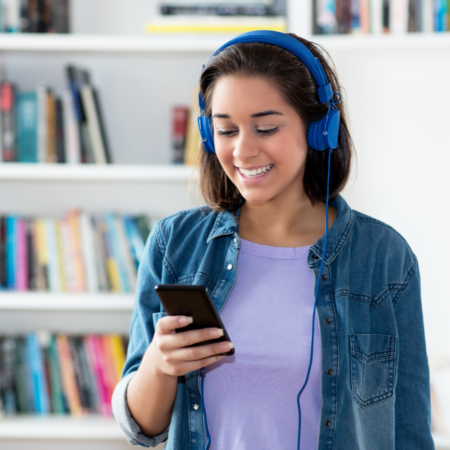Woman listening to podcast on headphones while learning podcast strategy and growth tips