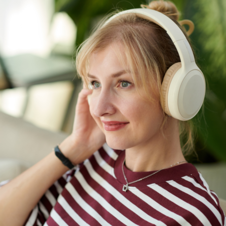 Woman listening to podcast about converting listeners to clients and tracking podcast metrics that matter for business growth