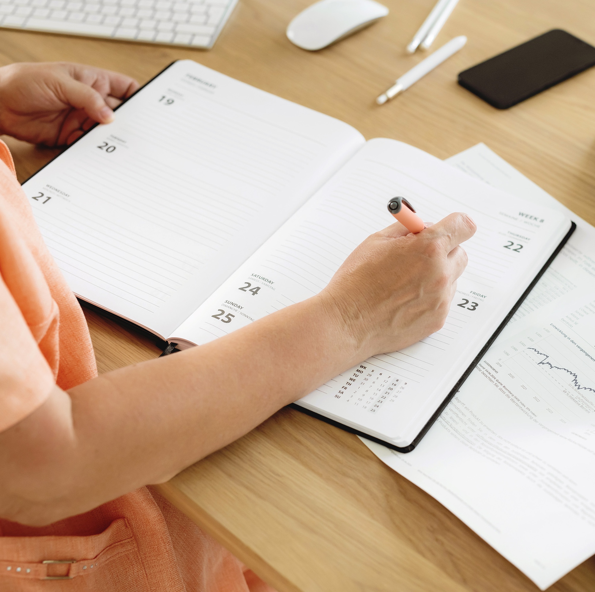 Podcaster sitting at desk with her podcast content calendar planning out her episodes.