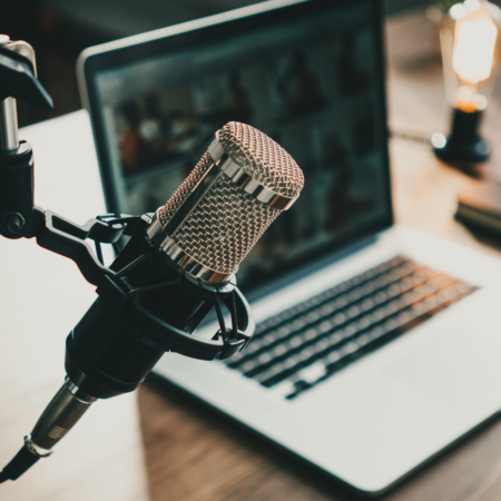 Professional podcast microphone and laptop setup for recording episodes with better podcast discoverability