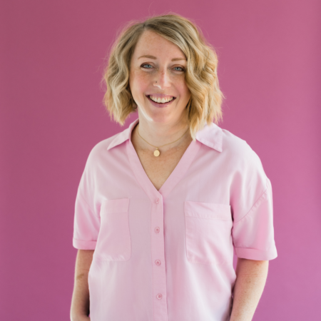 Allison Hardy, email marketing strategist, smiling in a pink button-down shirt against a pink background.