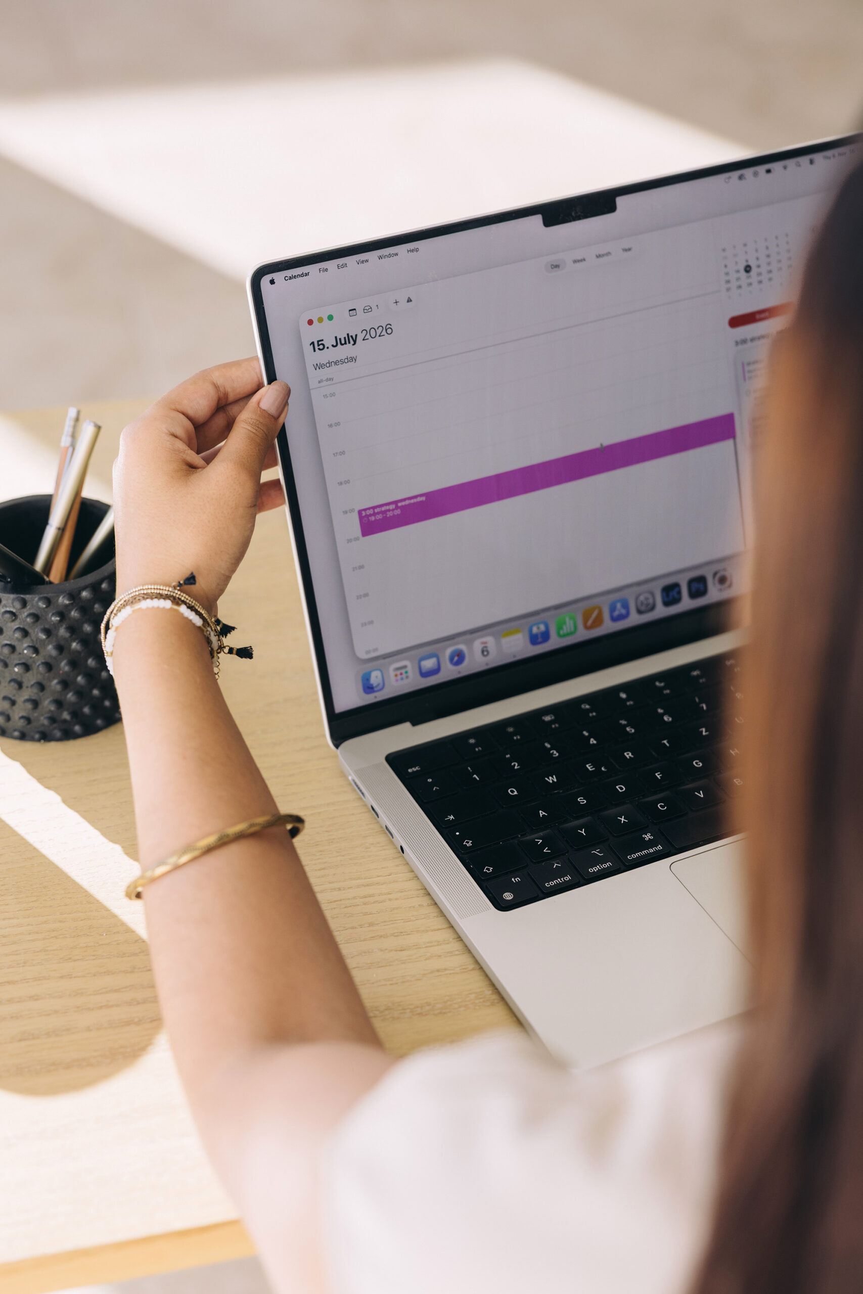 Woman reviewing her calendar on a laptop, blocking time to work on her podcast discoverability strategy.