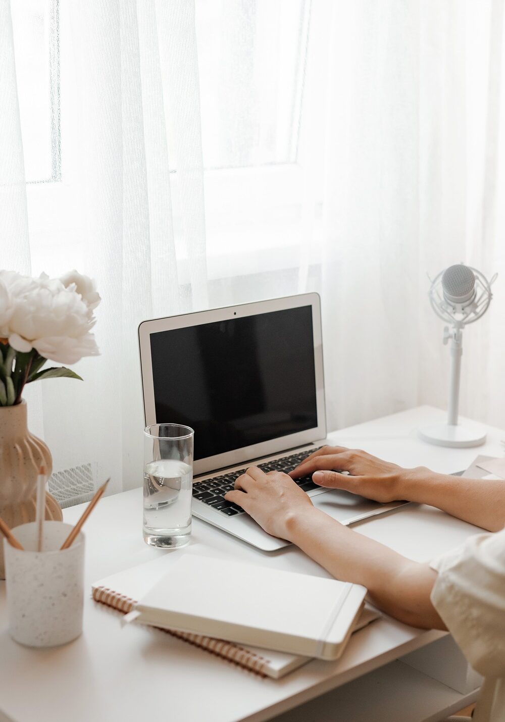business owner typing at laptop during podcast strategy call wtih Leah Bryant Co.